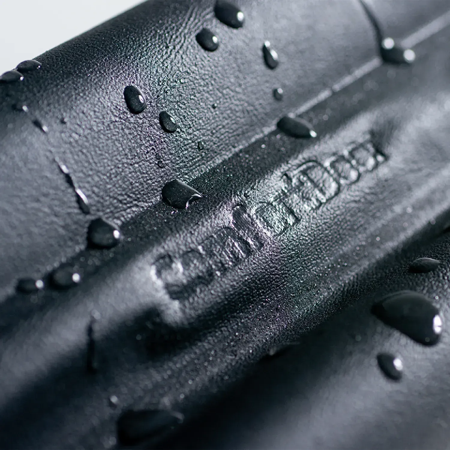 Veda-Porta-Rolinho-Comfort-Door-Preto-detalhe-da-marca